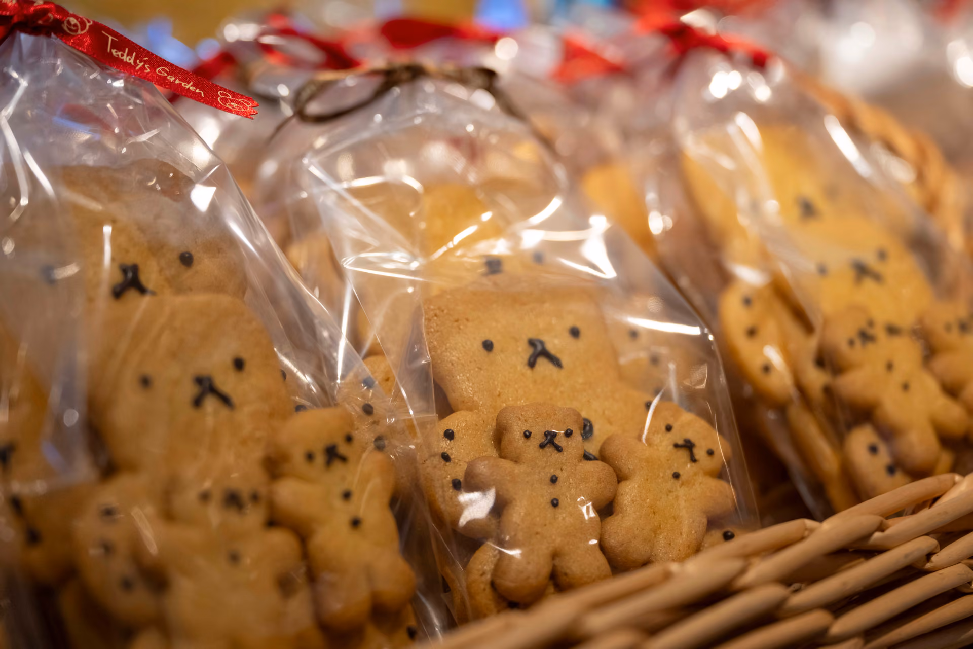 Teddy bear-shaped cookies in clear bags tied with red ribbons