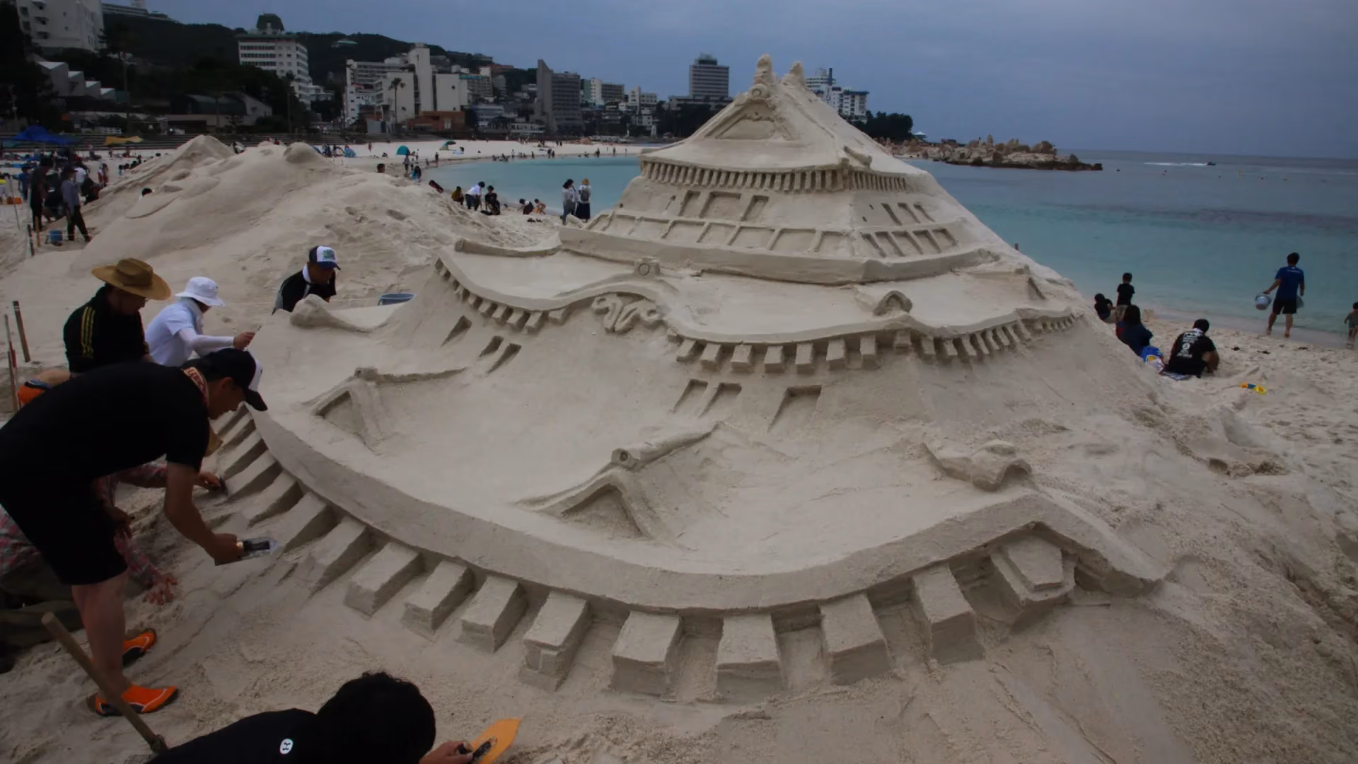 Sculptors carve an sand sculpture at the Sand Festival on Shirarahama Beach, Wakayama