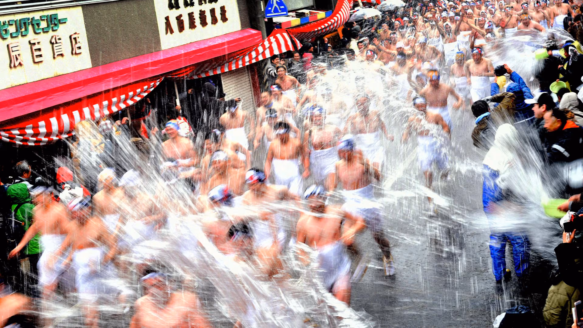 Participants in the Daito Ohara Mizukake Festival run through Ohara’s main street as spectators splash them with icy water.