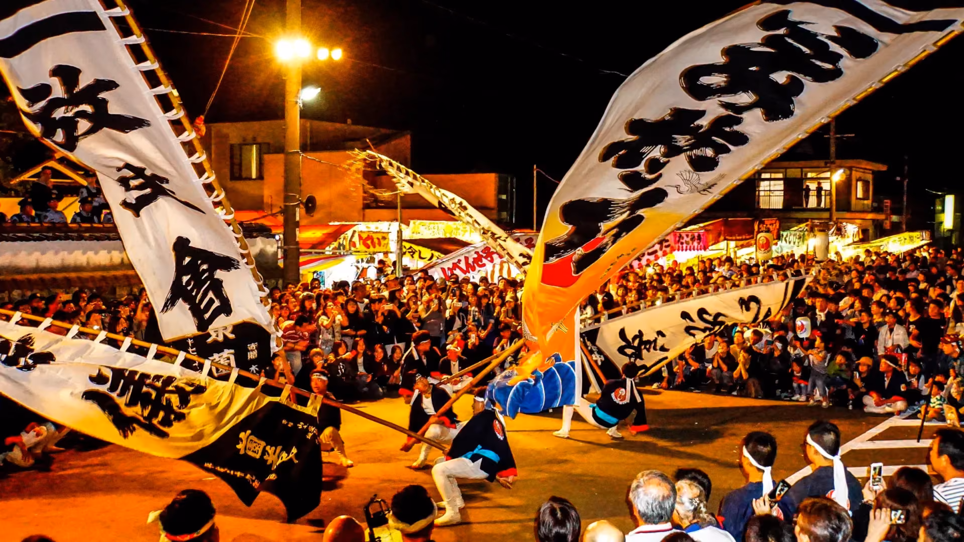 Bearers wield giant banners before the crowds at the Gobo Festival, Wakayama