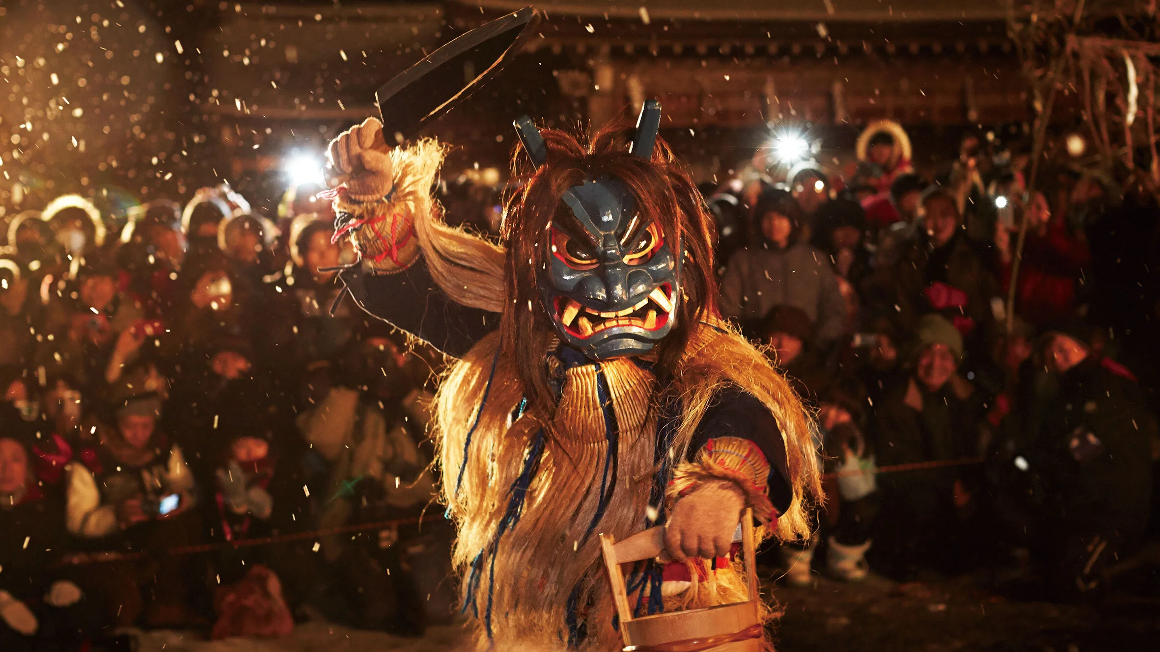 A performer in a fierce oni mask and straw costume at the Namahage Sedo Festival